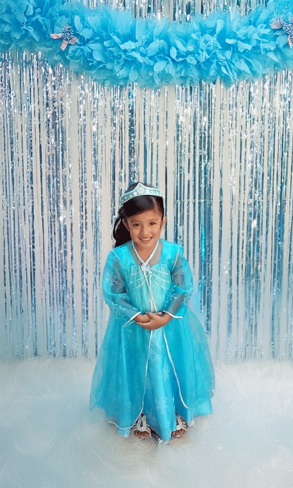 Detail of elegant dress, twinkling lights, and fresh flowers
